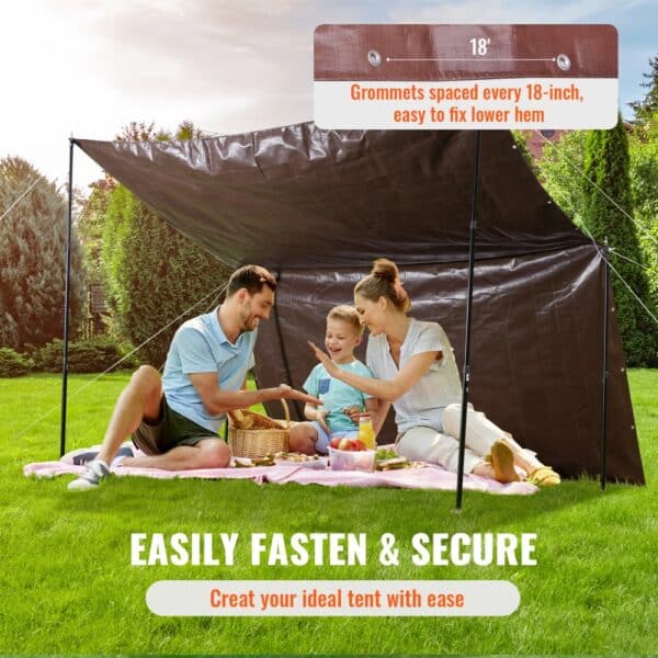 family enjoying a picnic under a VEVOR extra thick waterproof tarp with 18-inch spaced grommets.