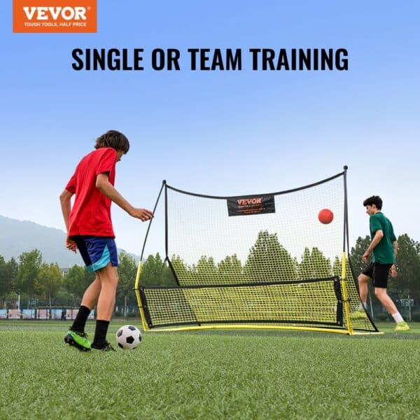 players training with a VEVOR soccer rebounder on a grassy field, with trees and hills in the background.