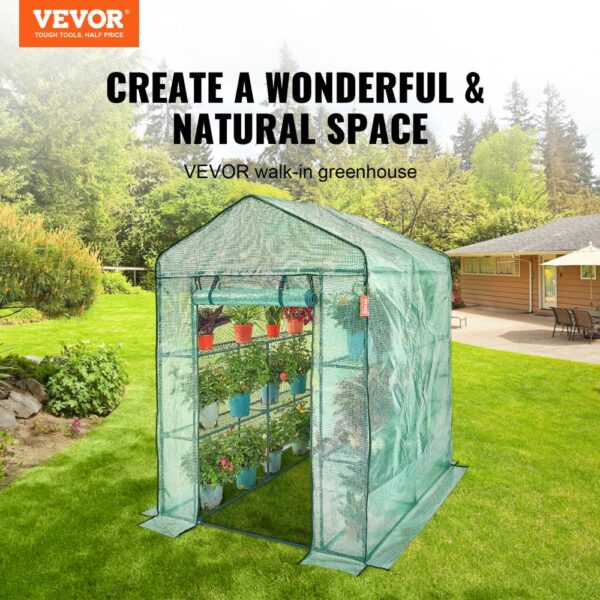 VEVOR walk-in greenhouse in garden with potted plants, open door, and a lawn and house in the background.